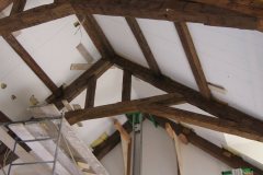 Hand hewn barn timber trusses and beams with dark brown wax
